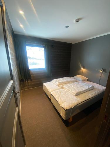 um quarto com uma cama e uma janela em Brobygget Mølla 101 em Kyrkjebøen