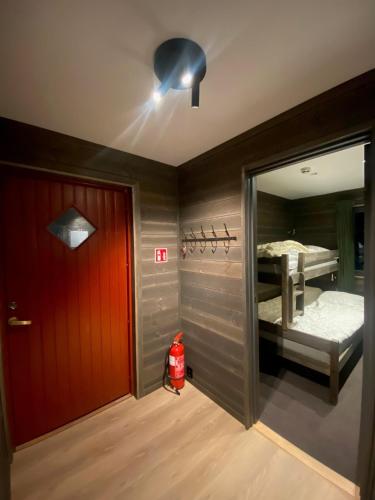 a room with a red door and a bedroom with a bed at Brobygget Mølla 101 in Kyrkjebøen
