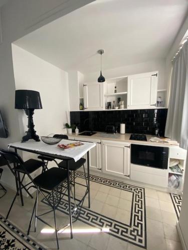 a kitchen with white cabinets and a table and chairs at Vittorio Emanuele Top Suite in Capri