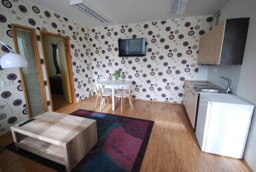 a small kitchen with a table and a refrigerator at City Apartment in Kuressaare