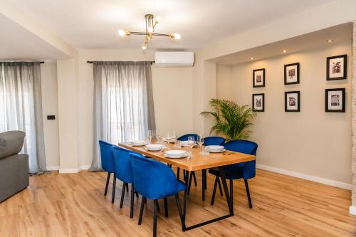 une salle à manger avec une table en bois et des chaises bleues dans l'établissement El Labrador, à Anna