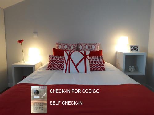 a bedroom with a red and white bed with two lamps at Casa Pirosa2 in Aveiro