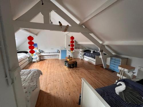 een slaapkamer op zolder met 2 bedden en een kamer met houten vloeren bij Charmante Art Deco rijwoning in Oostende