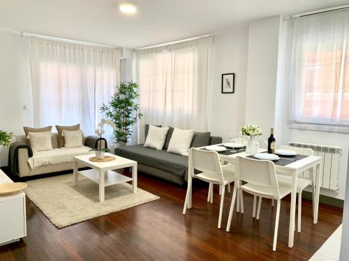 sala de estar con sofá, mesa y sillas en Apto Céntrico Piscina Garaje Incluido Urbanización, en Castro Urdiales