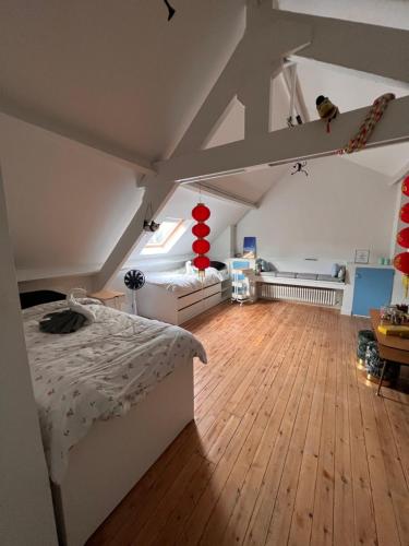 a bedroom with a white bed and a wooden floor at Charmante Art Deco rijwoning in Ostend