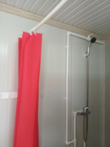 a shower with a red curtain in a bathroom at Camping Danubius Tulcea in Tulcea