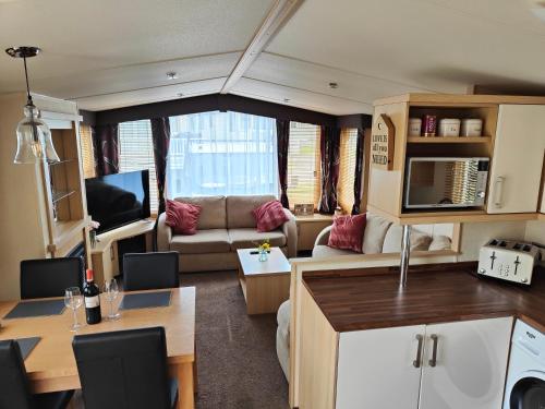 una cocina y una sala de estar con una caravana en Holiday home sleeps six, en Poole