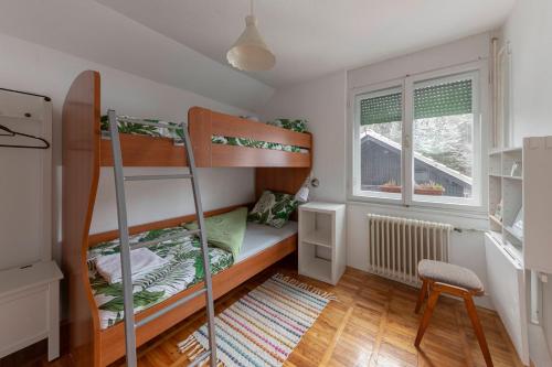Kleines Zimmer mit Etagenbetten und einem Schreibtisch. in der Unterkunft Vrtnarjeva hiša, The Gardener's Cottage in Radovljica