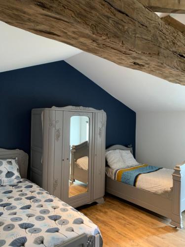 une chambre avec deux lits et un miroir dans l'établissement Appartement Cosy La Maison de Jean, à Oiron