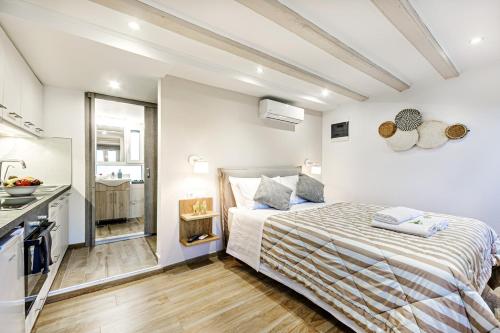 a small bedroom with a bed and a kitchen at Ionian Citizen Atelier in Corfu Town