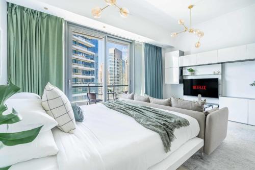 a bedroom with a large white bed and a large window at GuestReady - Concrete Jungle in Dubai