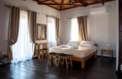 a bedroom with a bed and a table and chairs at Lemnos grand maison in Kondopoúlion