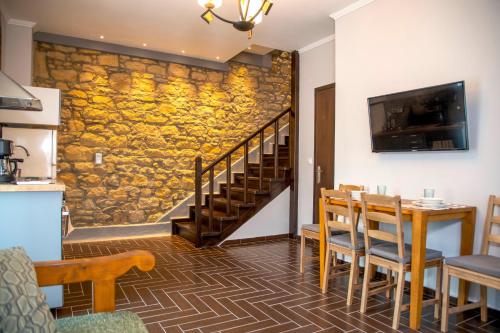 uma sala de jantar com uma mesa e uma parede de pedra em Lemnos grand maison em Kondopoúlion