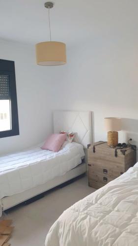 a bedroom with two beds and a wooden dresser at Villa de Lujo en Santa Margarita in Alcaidesa