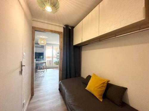 - un salon avec un canapé et un oreiller jaune dans l'établissement Studio Cosy climatisé Carnon Plage, à Carnon-Plage