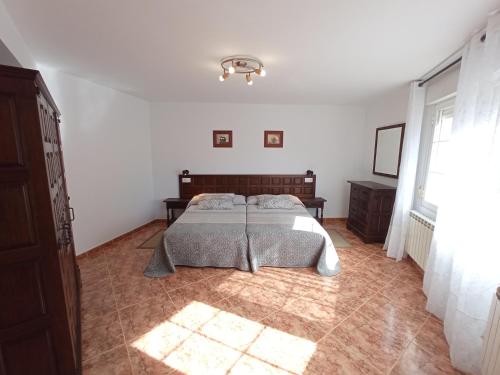 ein Schlafzimmer mit einem Bett in einem weißen Zimmer in der Unterkunft EL RINCON DE LUISA Y SANTOS in Ezcaray
