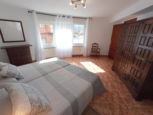 a bedroom with a bed and a window and a chair at EL RINCON DE LUISA Y SANTOS in Ezcaray