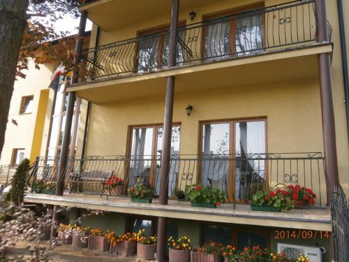 an apartment building with flowers on the balconies at Hotelik Komandor in Władysławowo