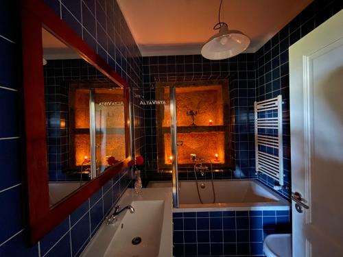 baño de azulejos azules con bañera y lavamanos en AltaVista en Vitorino dos Piães