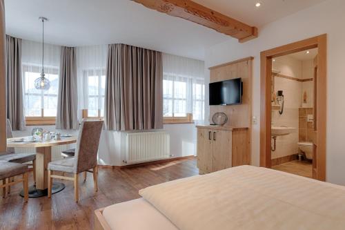 a bedroom with a bed and a table and a bathroom at Pension St. Florian in Sankt Johann im Pongau
