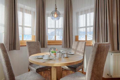 a dining room with a table and chairs and windows at Pension St. Florian in Sankt Johann im Pongau