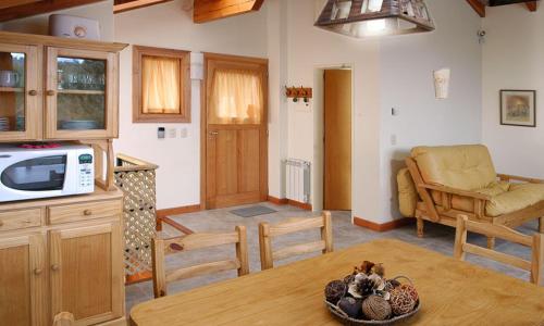 een keuken en woonkamer met een tafel en een bank bij Cabañas Carelmapu in Bariloche