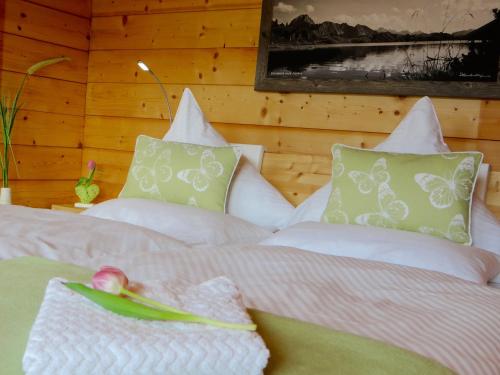 a bedroom with a bed with white sheets and green pillows at MEB Appartement in Blaichach