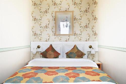 a bedroom with a bed and a picture on the wall at Casa Boutique Hotel in Nahariyya