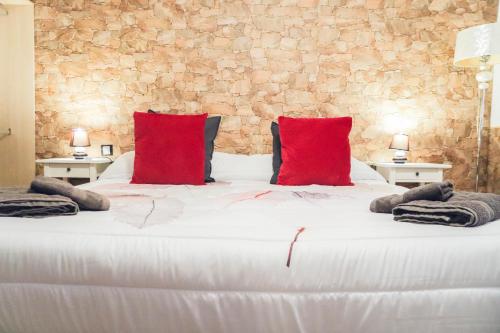 a bedroom with a large white bed with red pillows at LA CAÑADA in Tiscamanita