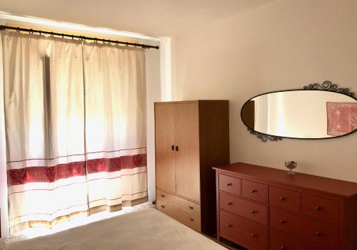 um quarto com um espelho, uma cómoda e uma janela em Casa in centro a due passi dal mare em Santa Teresa Gallura