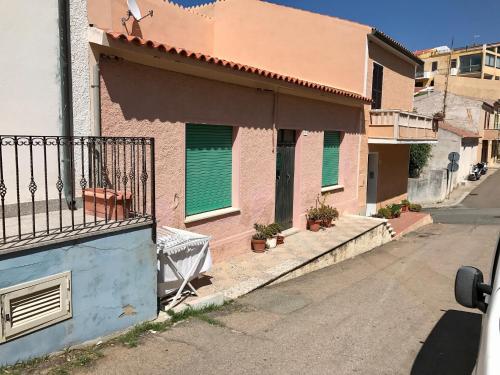 a building with green doors on a street at Casa in centro a due passi dal mare in Santa Teresa Gallura