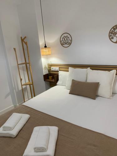 a large white bed with two white towels on it at APARTAMENTO MEDINA AZAHARA in Córdoba