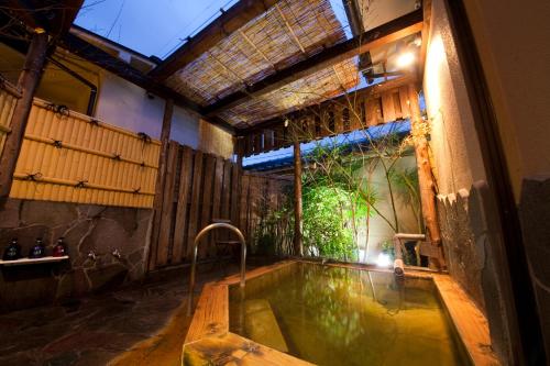 a bath tub in a room with a large window at Ryokan Sennari (13 years or older) in Beppu