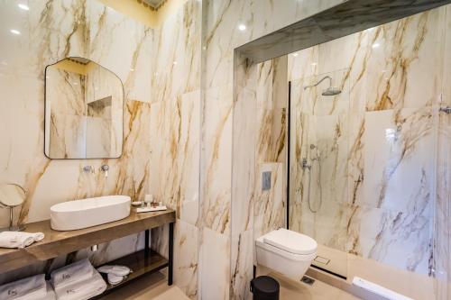 a bathroom with a sink toilet and a shower at EPICURE SUITES in Kavála