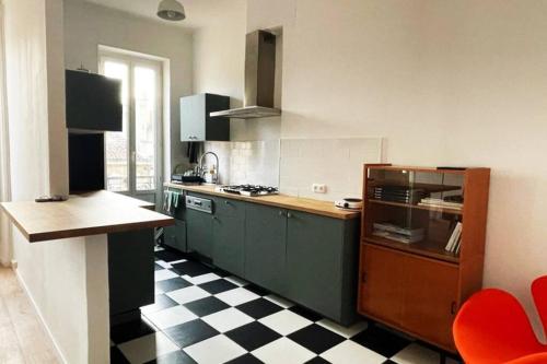 - une cuisine avec des placards verts et un sol en damier dans l'établissement Charmant appart / 4 pers / 2 ch / Noailles coeur Marseille, à Marseille