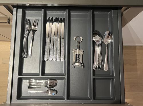 a black drawer with silver utensils in it at Swiss Art Apartment City Center in Zürich