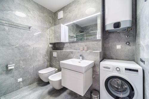 ein Badezimmer mit einer Waschmaschine und einem WC in der Unterkunft Golden view 7 in Split