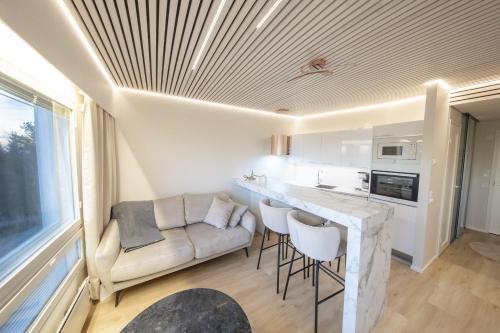 een keuken en een woonkamer met een bank en een tafel bij Tunturihuoneisto LAAKEUS in Syöte