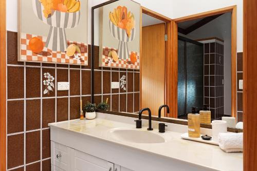 a bathroom with a sink and a mirror at Hinterland family getaway in Maleny