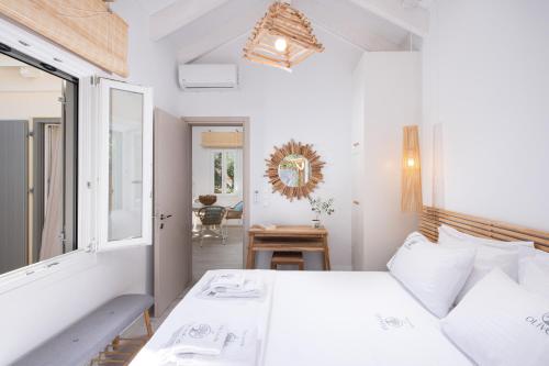 Olivea Premium Holiday Homes في Stavros: غرفة نوم بيضاء مع سرير وطاولة