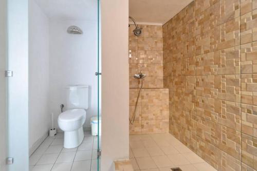 a bathroom with a toilet and a shower with a glass door at Beachfront Apartment Downtown close to Athens Airport in Artemida