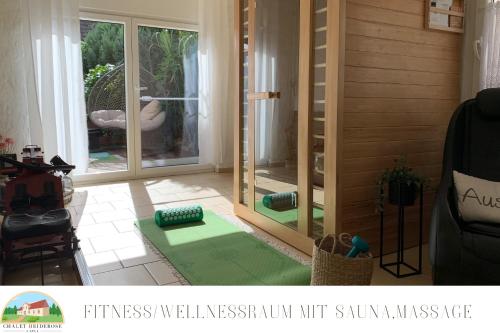 een woonkamer met een glazen schuifdeur bij Chalet Heiderose SPA - Kamin, Sauna & Wellness in Kluis