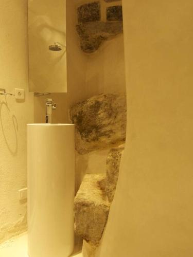 - une salle de bains avec un urinoir dans une chambre avec des rochers dans l'établissement Le Studio 04 Ramatuelle Vieux Village, à Ramatuelle