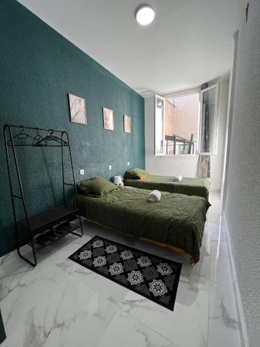 una camera con due letti e una parete verde di Chambre privée Emmanuel Lourdes a Lourdes