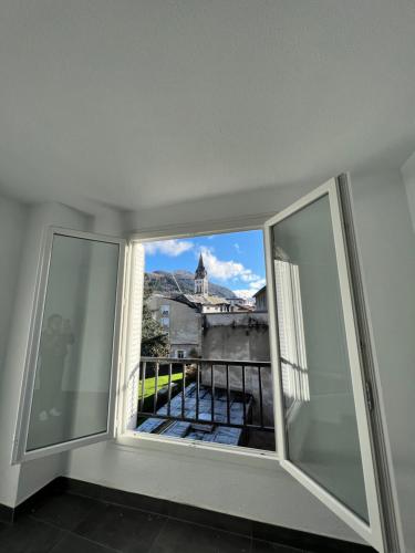 - une fenêtre dans une chambre avec vue sur un bâtiment dans l'établissement Chambre privée Emmanuel Lourdes, à Lourdes