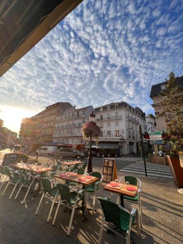 um grupo de mesas e cadeiras numa rua da cidade em Chambre privée Emmanuel Lourdes em Lourdes