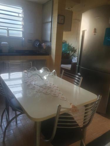 a kitchen with a white table and a refrigerator at Hospedagem em Delcastilho in Rio de Janeiro