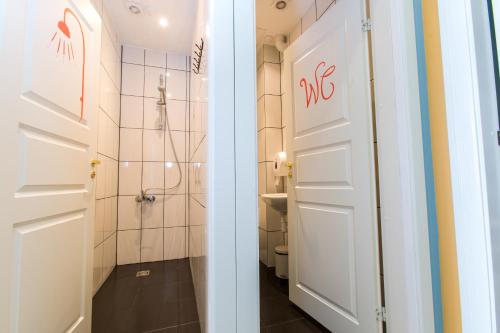 a bathroom with a shower and a white door at Old Town Hostel Alur in Tallinn