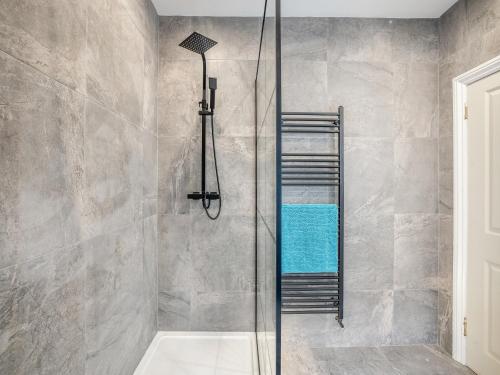 a shower with a glass door in a bathroom at Llety Clyd in Barmouth