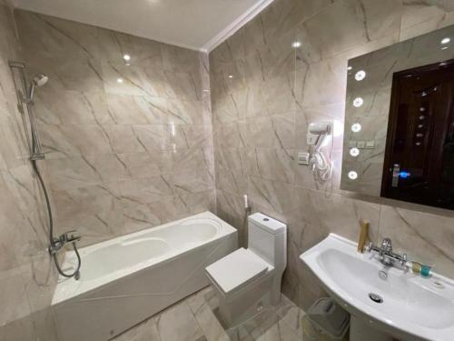 een badkamer met een bad, een wastafel en een toilet bij شقق سويت ستار الفندقية in Tabuk